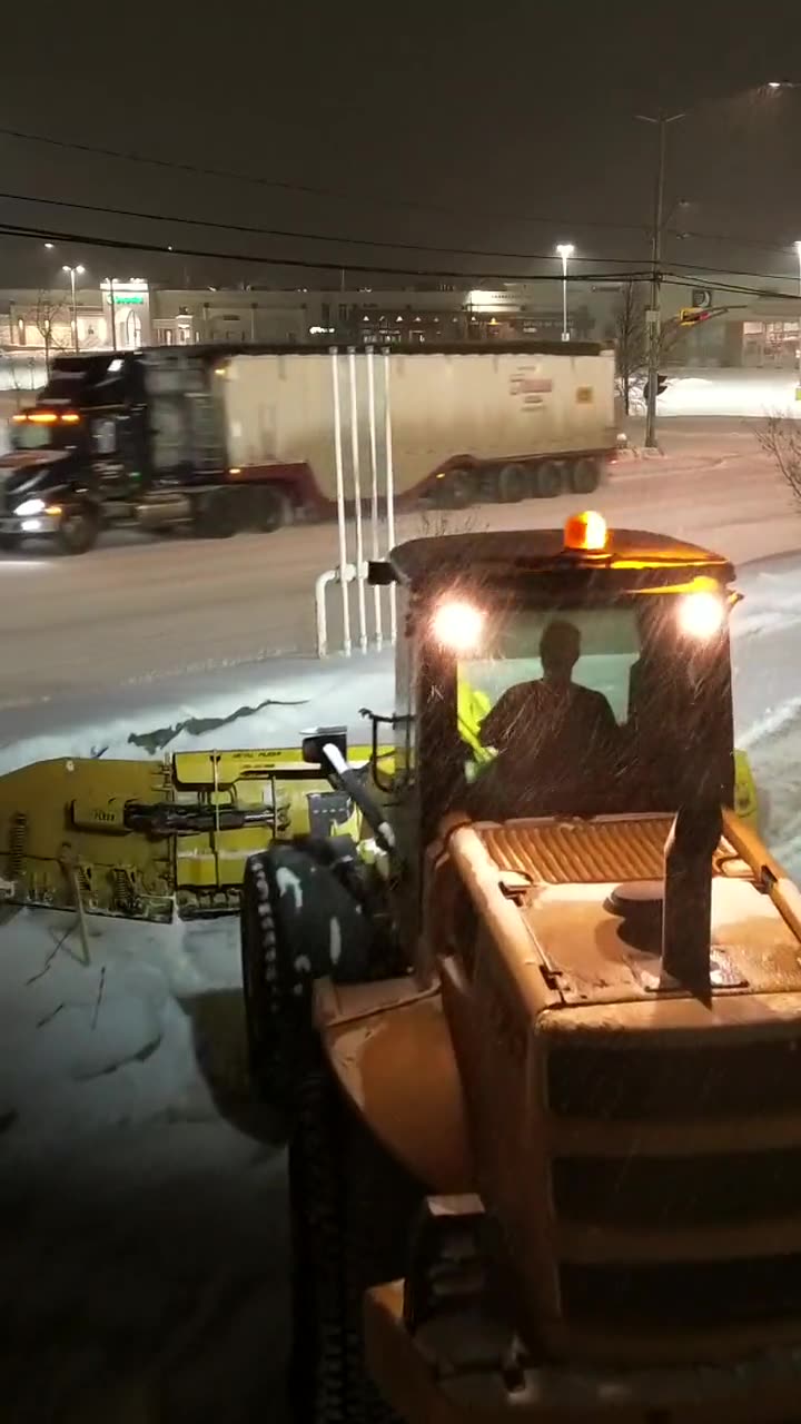 Chargeuse de déneigement la nuit, vue de drone